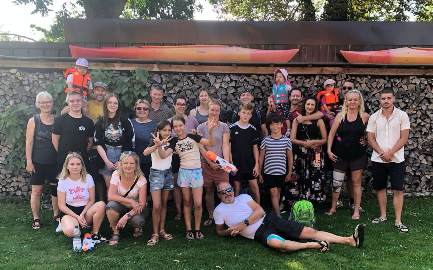 Große Gruppe von Familien mit Kindern, Wasserspritzpistolen und Schwimmwesten vor Booten im Spreewald
